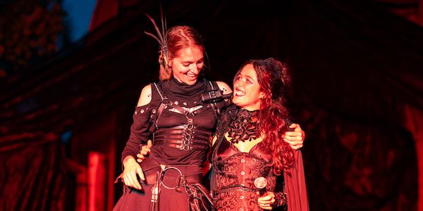 Fringe Directors Niikah and Taylor smiling at each other on stage at the Fall Phantasm